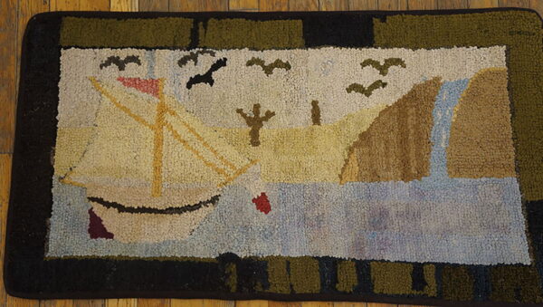 Textured rug featuring a cream sailboat, brown land, and blue water, framed by an olive and black border.