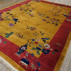 Golden yellow high-pile rug with sprawling blue and purple floral vines and a wide red border on wood flooring.