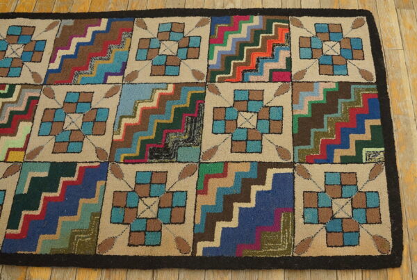 Textured rug with a multicolored zigzag and checkerboard block pattern lying on light wood flooring.