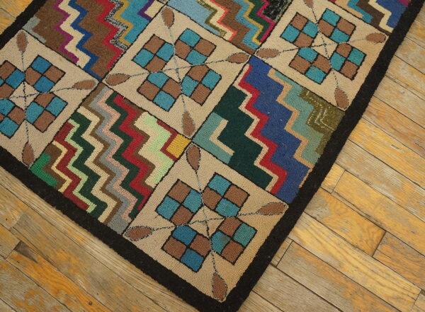 Multi-colored, textured rug with geometric squares and zigzags lies diagonally on yellowed hardwood planks.