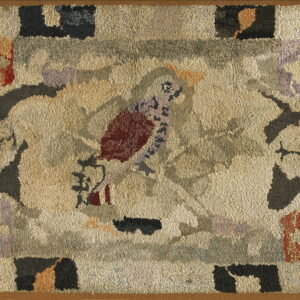 Textured beige rug featuring a folk art style bird and geometric blocks in muted red, purple, and gray.