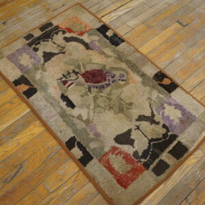 Textured, multicolored abstract rug in muted tones of green, beige, red, and lavender on rustic wood flooring.
