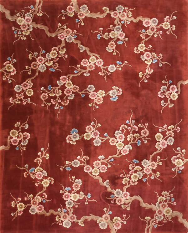 Red low-pile rug with sprawling beige branches and pink, mauve, and blue blooming flowers.