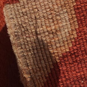 Close-up detail showing two rug textures: shaggy rust pile and a tightly woven beige and orange stripe.