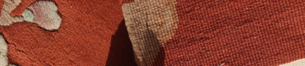 Close-up detail showing two rug textures: shaggy rust pile and a tightly woven beige and orange stripe.
