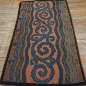 Textured runner rug with large navy scrolls on a salmon field and wavy borders on distressed wood planks.