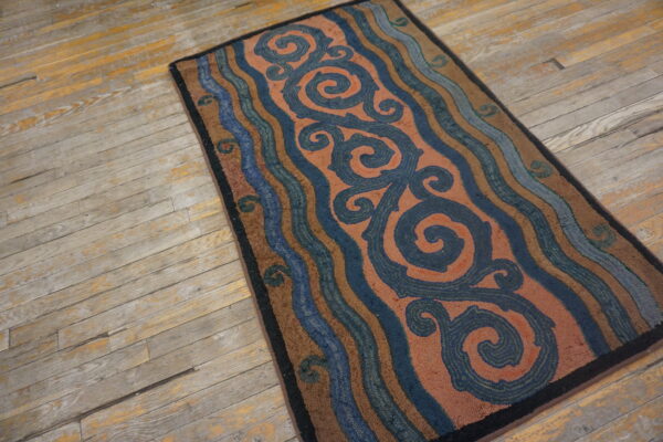 Rustic rug with navy scrolls and brown, blue, rust wavy stripes on distressed wood planks.
