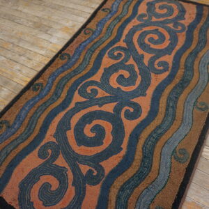 Textured runner with coral scrolls and blue wavy stripes on distressed wooden floorboards.