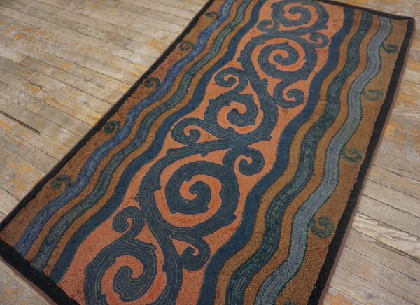 Textured runner with coral scrolls and blue wavy stripes on distressed wooden floorboards.