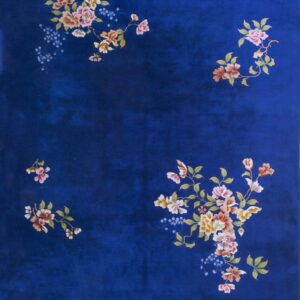 A deep blue rug with a plush texture displays scattered clusters of multicolored floral motifs.