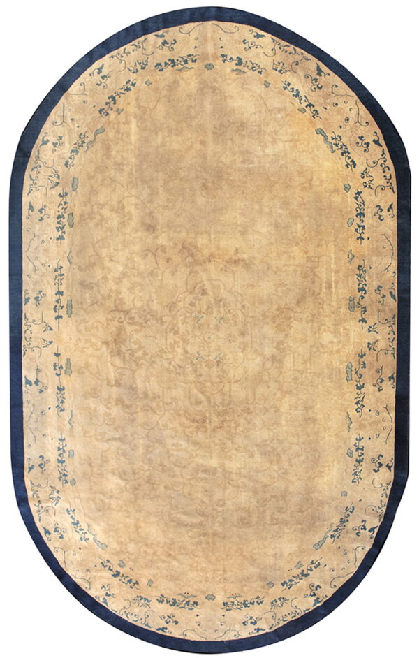 Oblong beige rug with a faint field pattern and a distinctive dark blue scrolling border and edge.