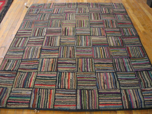 Multicolored striped high-pile rug laid in a repeating rectangular block pattern on a wooden floor.