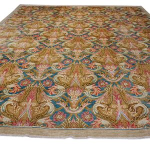 Golden brown and teal rug with intricate symmetrical motifs and accents of rose pink.