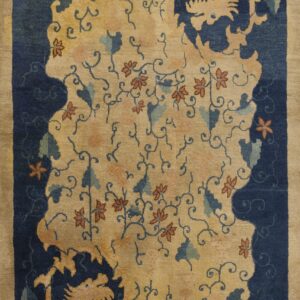 Tan and navy rug with a central island of flowers and vines, bordered by stylized dragons.