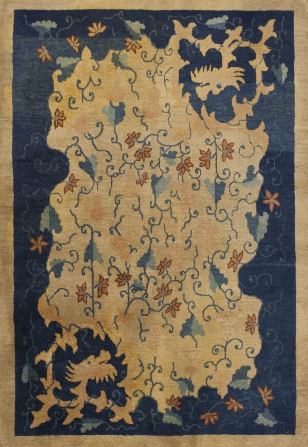 Tan and navy rug with a central island of flowers and vines, bordered by stylized dragons.