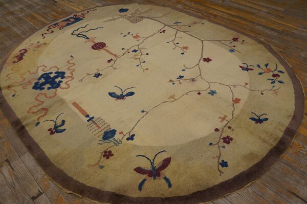 Round low-pile rug featuring a delicate floral and butterfly pattern on a light beige field over wood planks.