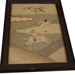 Framed tapestry or rug panel depicts figures on a horse and running, with birds in a beige and gray landscape.