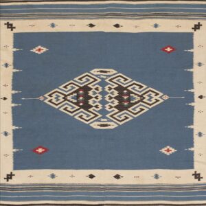 Flatweave rug with a blue field, cream border, and large black and white central geometric design.