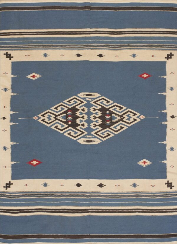 Flatweave rug with a blue field, cream border, and large black and white central geometric design.