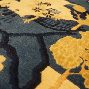 Plush rug detail showing yellow tree designs and carved outlines against a deep blue background.