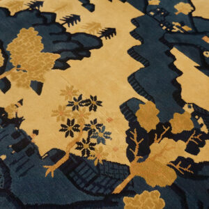 Medium pile rug with a blue and tan stylized landscape design featuring carved details.
