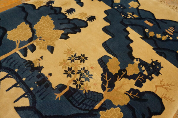 Medium pile rug with a blue and tan stylized landscape design featuring carved details.