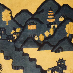 Blue and yellow scenic rug depicting stylized mountains, a pagoda, and structures, visible next to wood floors.