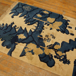 Blue and beige scenic landscape rug with stylized mountains and trees, displayed on rustic wood floors.