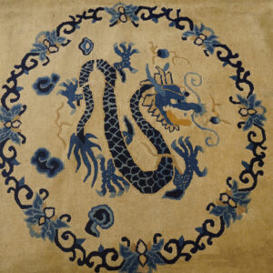 Tan rug field featuring a central dark blue dragon motif surrounded by a detailed blue and navy floral border.