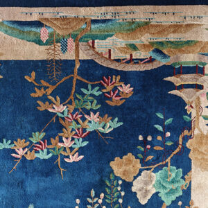 Deep blue rug detail featuring a scenic pattern of flowering vines, tan landscapes, and pagodas.