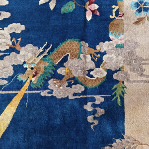 Deep blue rug with a detailed dragon pattern breathing yellow fire amidst gray clouds and colorful botanicals.
