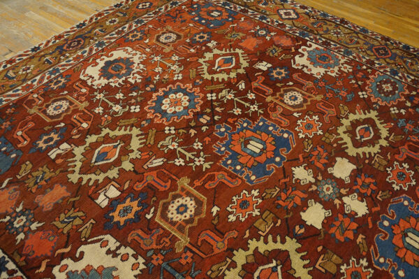 Low pile rug featuring dense geometric patterns in rust, blue, cream, and orange on hardwood flooring.