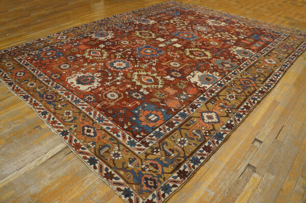 Ornate patterned rug in deep red, blue, and gold tones on distressed wood flooring.
