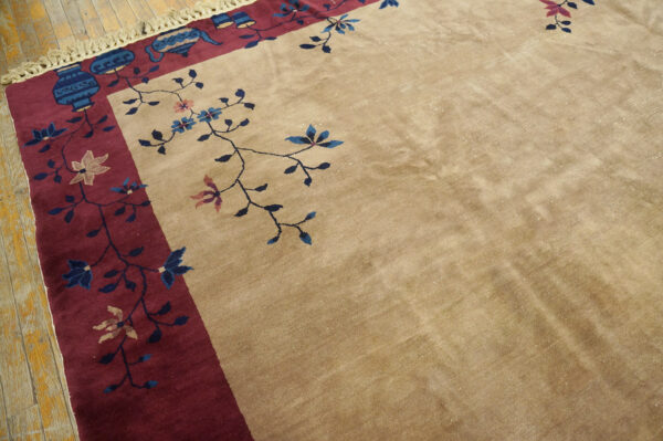 Low-pile beige rug with a dark red border patterned with blue vessels and delicate pink and blue flowers.