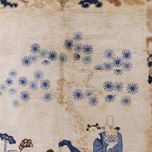 Cream rug with blue floral starbursts, a tan tree trunk, and figures along a blue and brown patterned border.