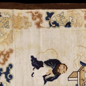 Medium pile cream rug corner detail showing traditional figures and cloud shapes in blue, tan, and brown.