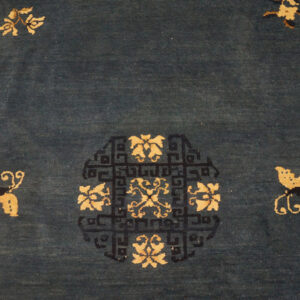 Deep blue rug with a golden floral medallion detailed in black fretwork and surrounded by small motifs.