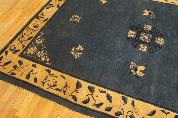 Wool hand knotted pile rectangle antique blue ivory beige cream white 1920s rug 13 Low-pile indigo rug with gold border and stylized floral and butterfly patterns on hardwood.