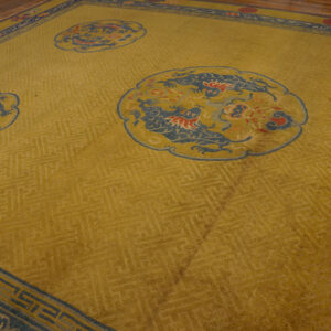 Mustard yellow rug featuring blue and red dragon motifs inside scalloped medallions and a dark blue border.