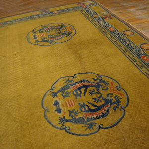 Yellow patterned rug with blue dragon roundels and red accents rests on light brown wood floor.
