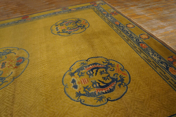 Yellow patterned rug with blue dragon roundels and red accents rests on light brown wood floor.