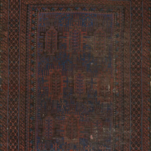 Distressed rectangular rug featuring complex geometric patterns in deep blue, rust red, and dark brown.
