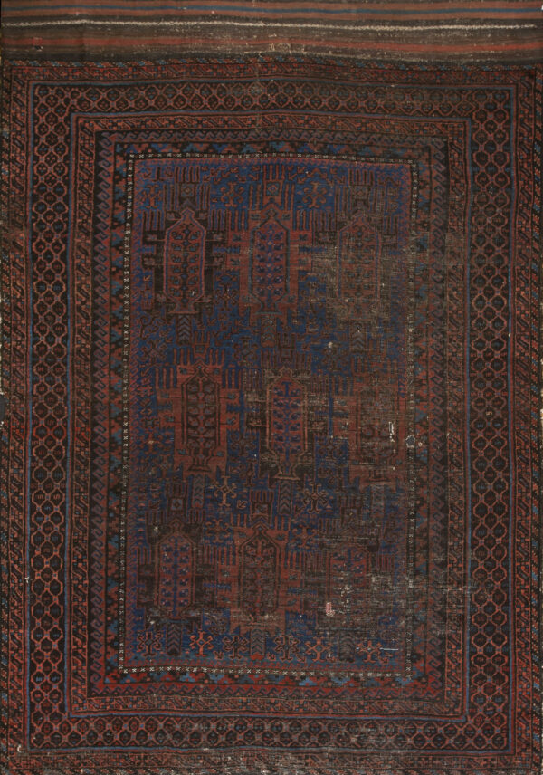 Distressed rectangular rug featuring complex geometric patterns in deep blue, rust red, and dark brown.