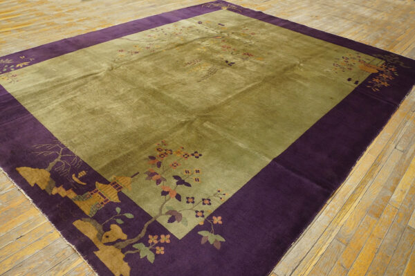 Lustrous olive green rug with plush pile and wide purple border featuring stylized floral and pagoda designs on wooden floor.