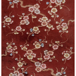 Deep red rug with high pile displays a pattern of flowering branches and multicolored blossoms.