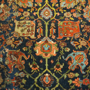 Intricate traditional rug pattern featuring tight knots and worn texture in teal, rust, navy, and pink.