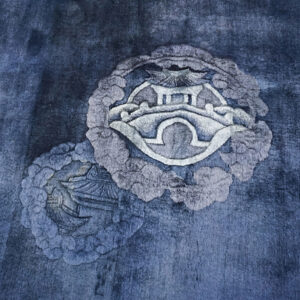 Deep blue pile rug featuring carved dragon designs and light fringe on glossy hardwood flooring.
