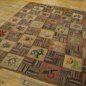 Earth tone checkerboard rug with multicolored floral motifs and striped blocks covers a distressed wood floor.