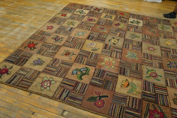 Earth tone checkerboard rug with multicolored floral motifs and striped blocks covers a distressed wood floor.