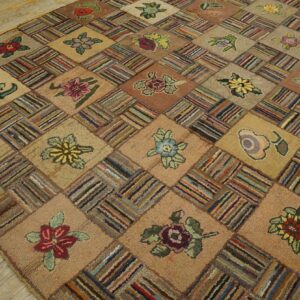 A highly textured patchwork rug features alternating floral motifs and multicolored striped squares on wood flooring.